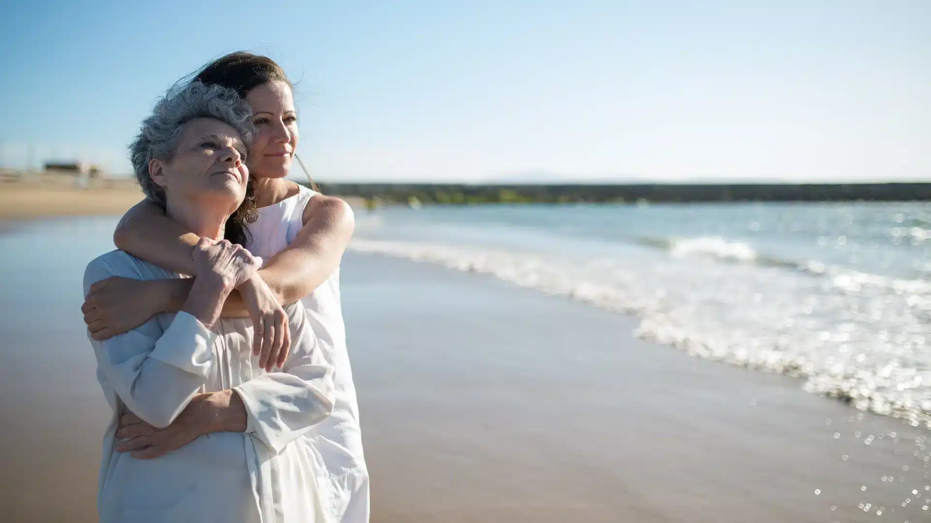Womens walking along the shore with ocean in background