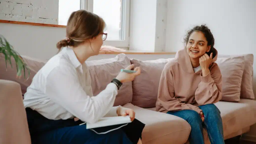 Therapist talking with a young woman during a counseling session about residential trauma care and insurance coverage.