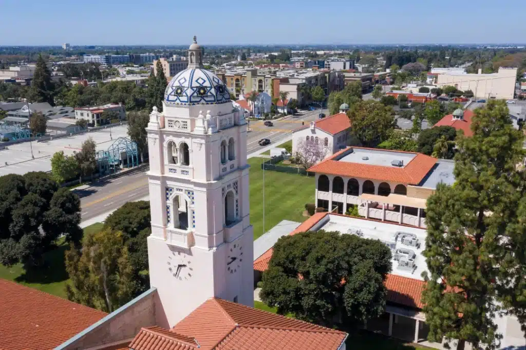 Aerial view of Fullerton, California showing city streets, residential neighborhoods, and nearby hills under clear blue sky.