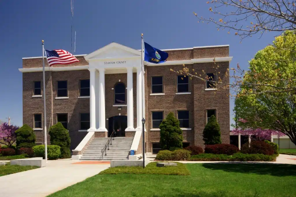 Stanton City Hall with white columns, American flag, and landscaped lawn in Stanton, California
