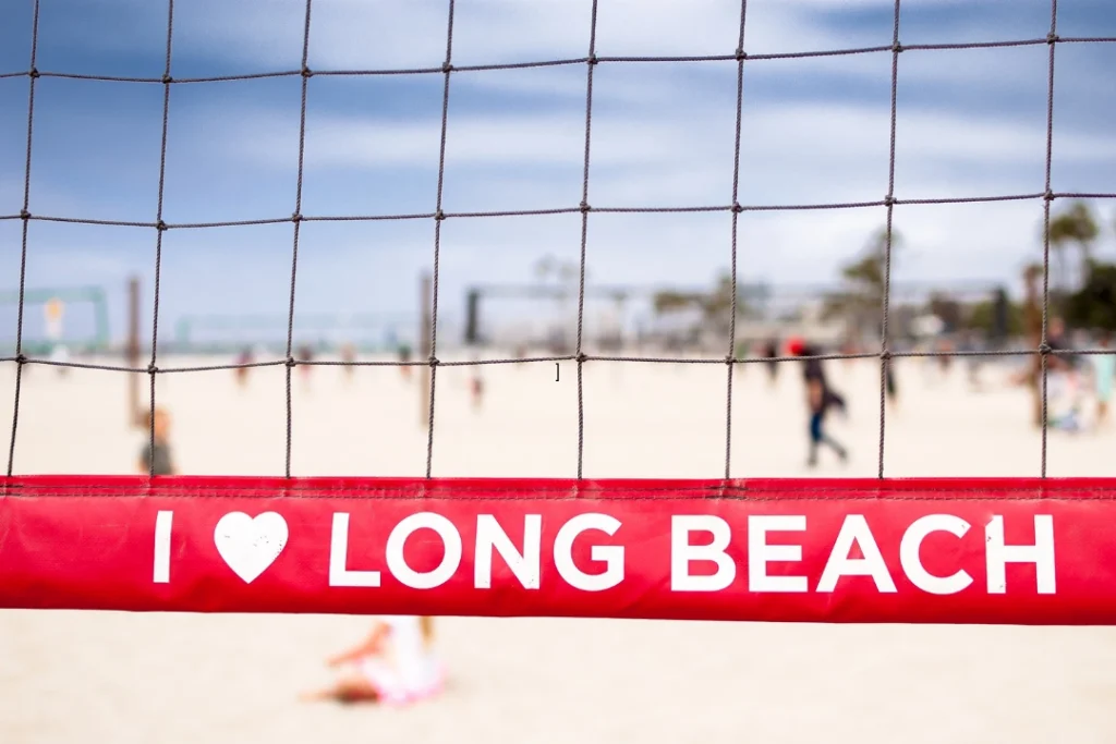 Beach volleyball courts in Long Beach with the iconic "I ❤️ Long Beach" sign in the foreground.
